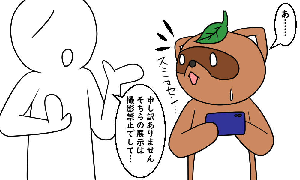 うっかり撮影禁止の展示物にカメラを向けてしまい、注意されるタヌキ
